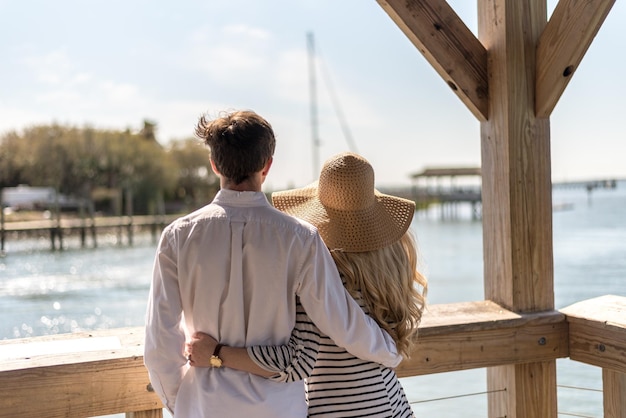 Rear view of couple standing at gazebo against sky