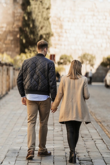 Rear view of a couple walking hand in hand People