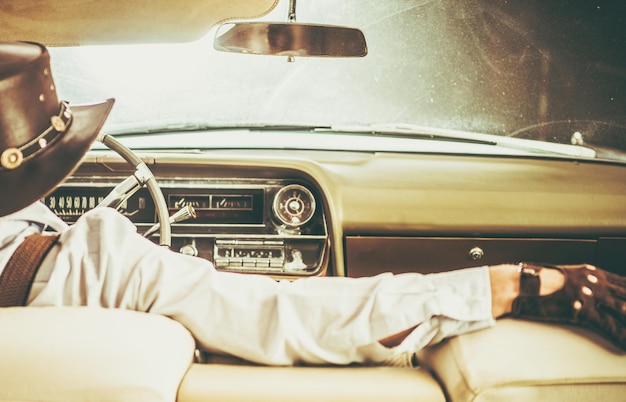 Photo rear view of cowboy driving car