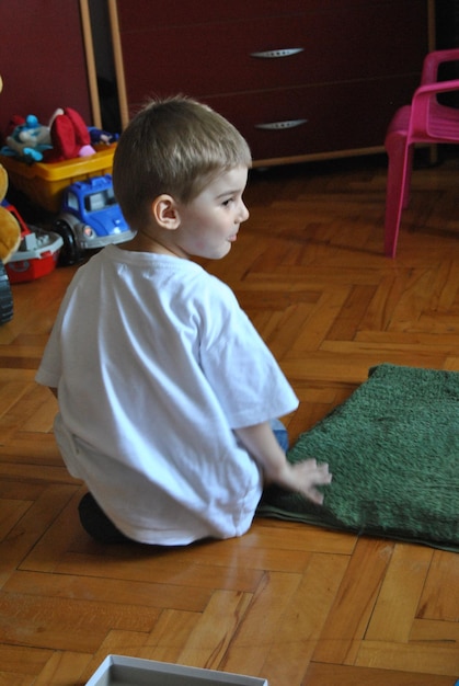 Rear view of cute boy looking away sitting at home