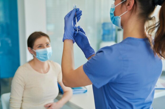 Photo rear view of doctor holding syringe