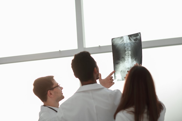 Foto retrovisore. medici che esaminano la radiografia del paziente. il concetto di salute