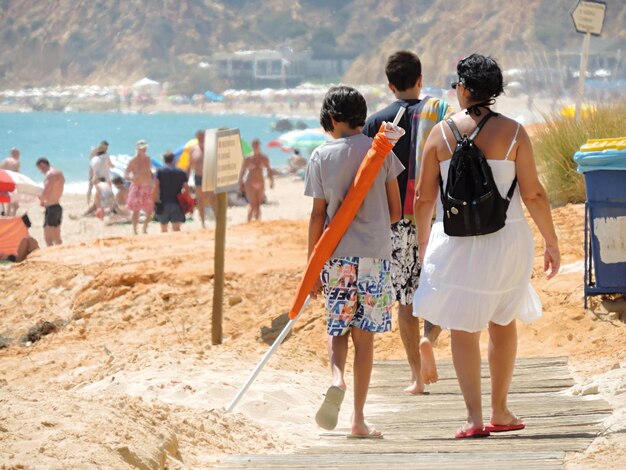 Foto vista posteriore di una famiglia che cammina sulla spiaggia