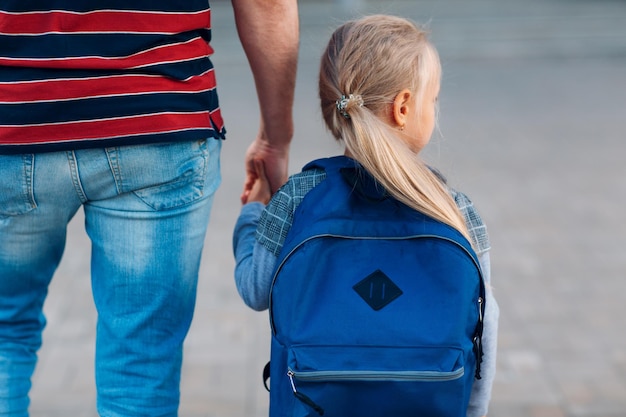 Rear view of father and daughter walking at street