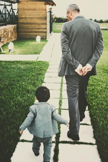 Foto vista posteriore di padre e figlio che camminano sull'erba