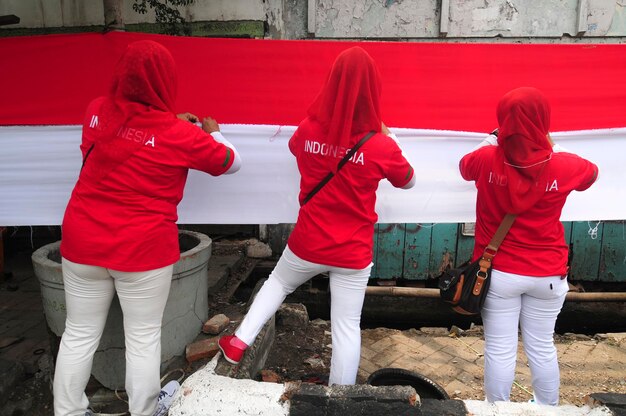 Photo rear view of females standing against fabric