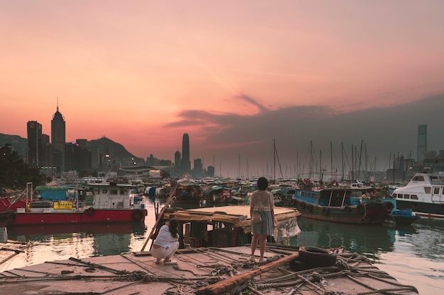 Rear view of females standing on boat against sky