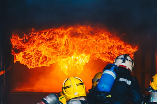 Rear view of firefighters extinguishing fire