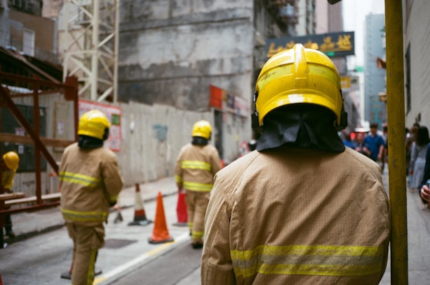 Foto vista posteriore dei vigili del fuoco che camminano per strada