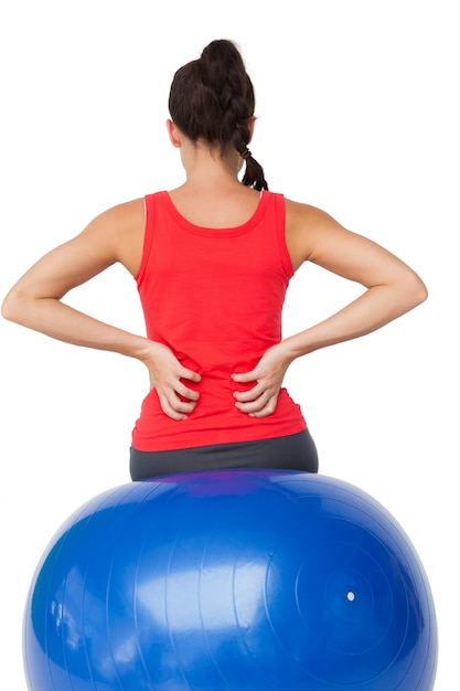 Rear view of a fit young woman sitting on exercise ball