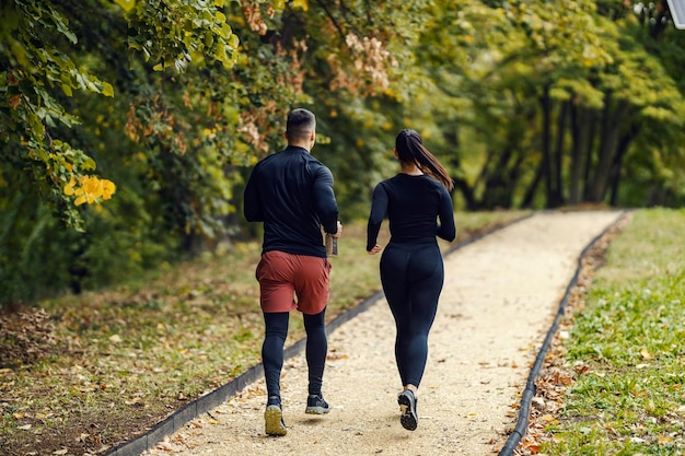 Photo rear view of a fitness couple running on the trail in nature