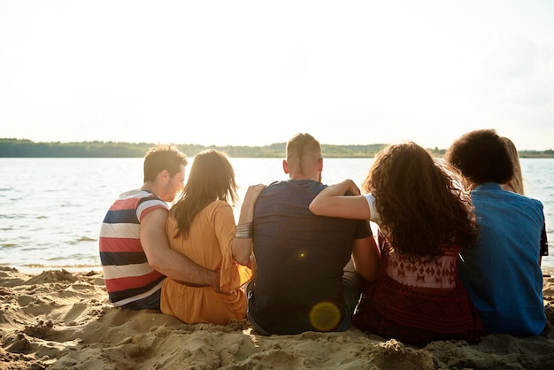 Photo rear view of friends sitting at beach