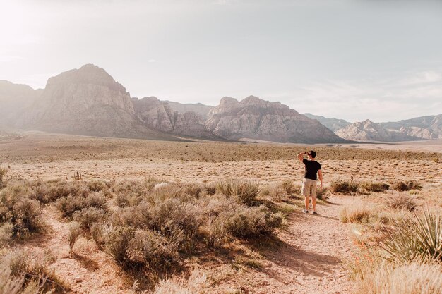 Photo rear view full length of man standing at desert against sky