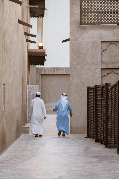 rear view full length of men wearing traditional clothing walking outside buildings