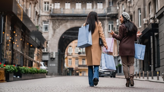 Rear view full length shot of female friends out for shopping in the city