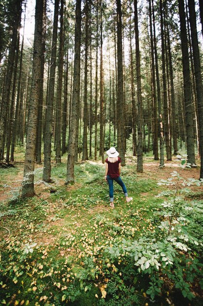 Foto vista posteriore a tutta lunghezza della donna in piedi nella foresta