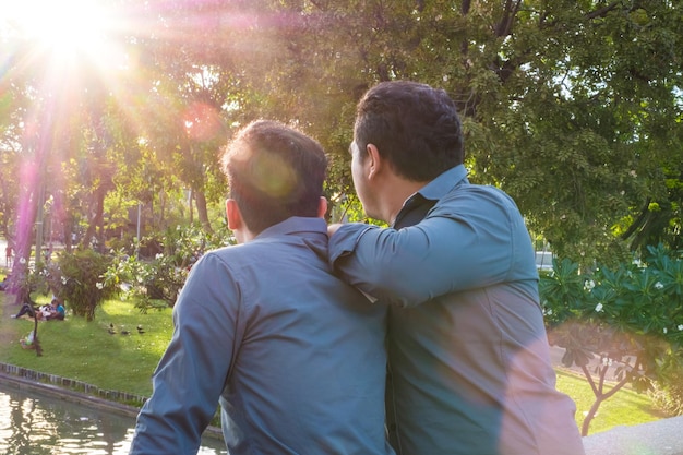Photo rear view of gay couple at park
