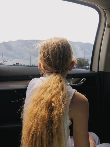 Photo rear view of girl against car window