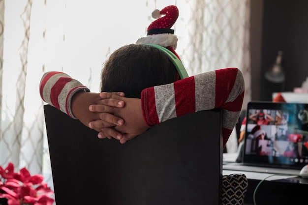 Photo rear view of girl during virtual christmas meeting