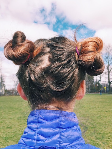 Photo rear view of girl on field against sky