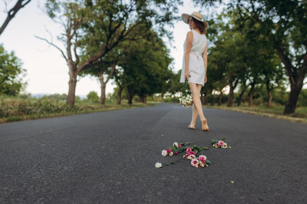 道路で花束を手に持った女の子の後姿 離婚 道路に花束