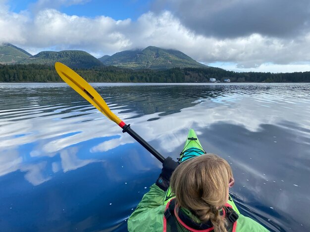 Photo rear view of girl on lake against sky