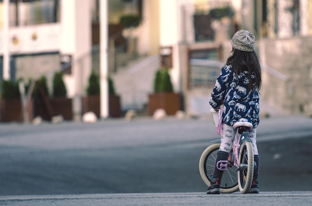 街で自転車に乗っている女の子の後ろの景色