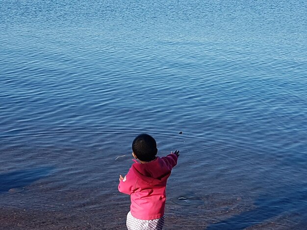 Rear view of girl standing at beach