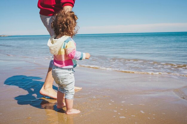 Foto vista posteriore di una ragazza in piedi sulla spiaggia