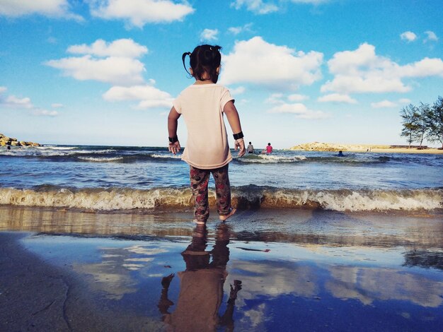 Rear view of girl standing on beach