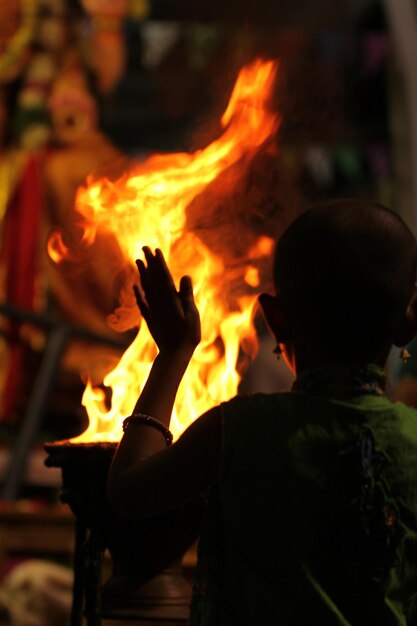 Photo rear view of girl standing by bonfire at night