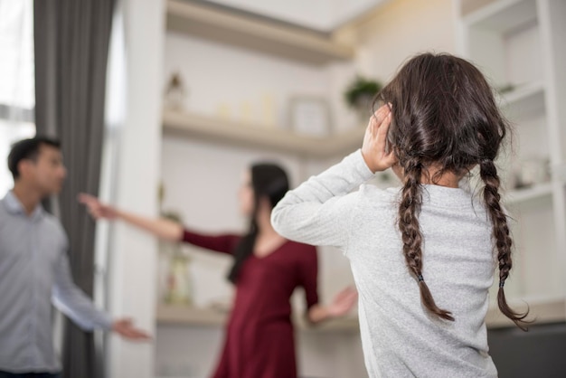 Foto vista posteriore di una ragazza in piedi con i genitori che litigano a casa