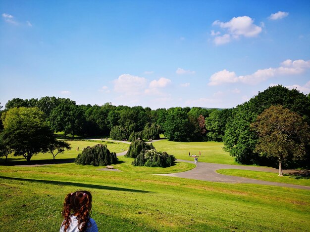 Foto vista posteriore di una ragazza in piedi nel parco contro il cielo