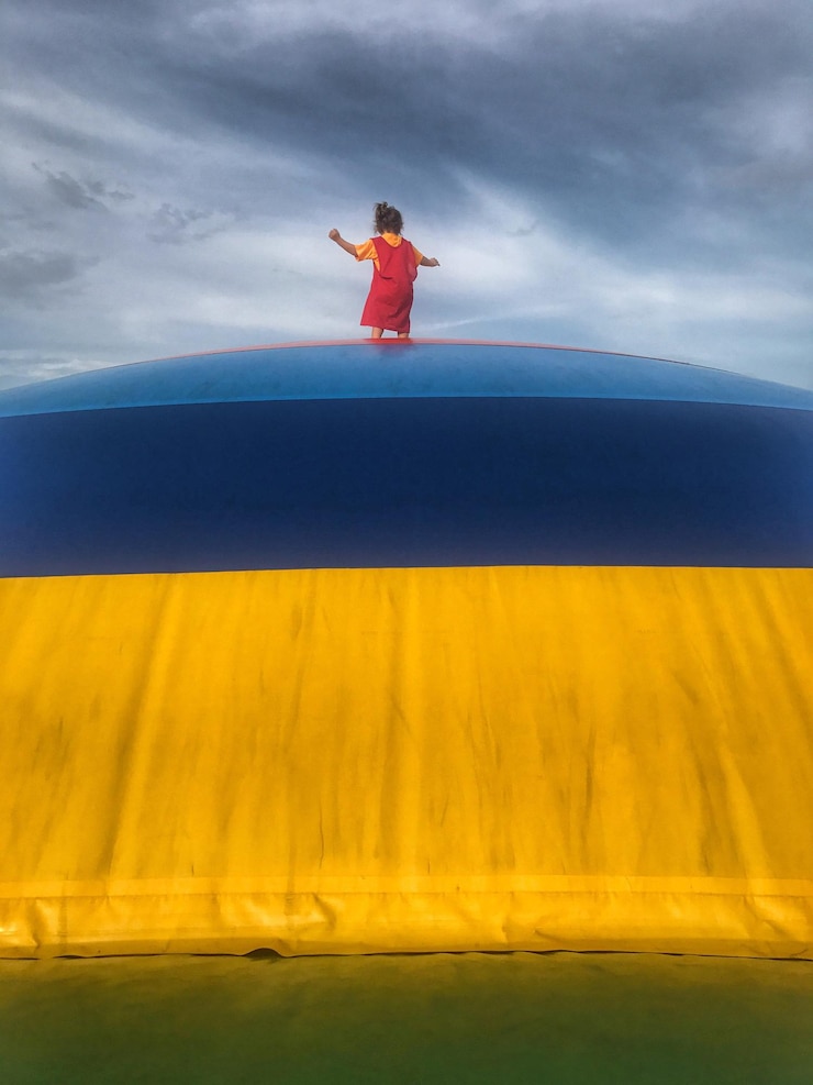 Фотография задний вид девушки, стоящей на игровом оборудовании на облачном небе