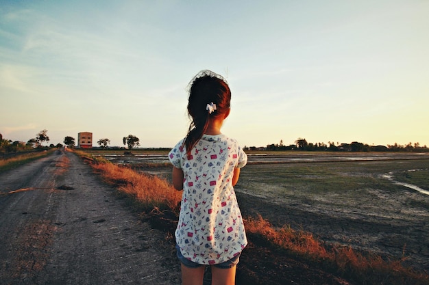 Photo rear view of girl standing on road