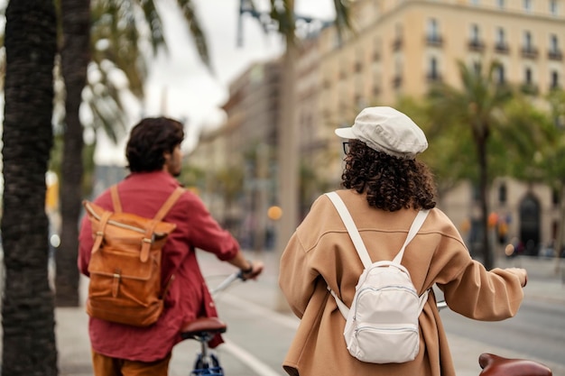 Rear view of a girl on street pushing her bike