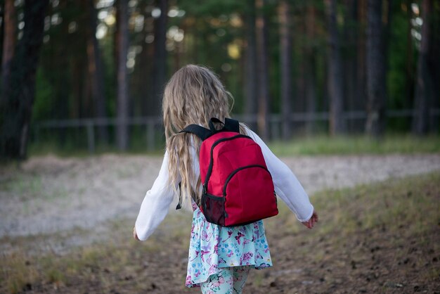 Photo rear view of girl walking in forest