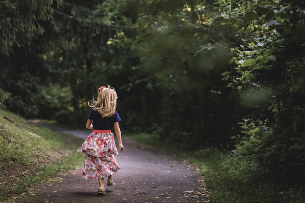 道路を歩いている女の子の後ろの景色