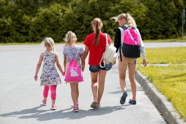 Photo rear view of girls walking on road