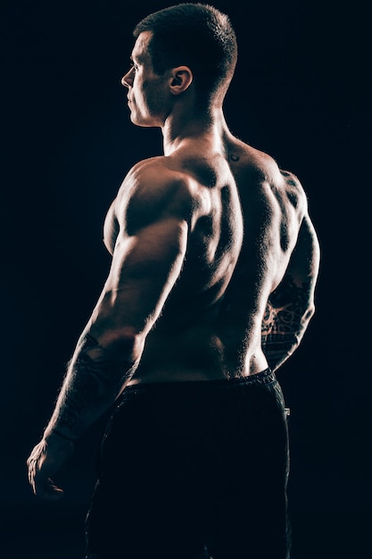 rear view.handsome male bodybuilder .isolated on black background