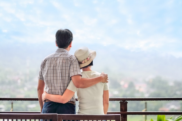 Rear view of a happy asian middle aged a couple on bench