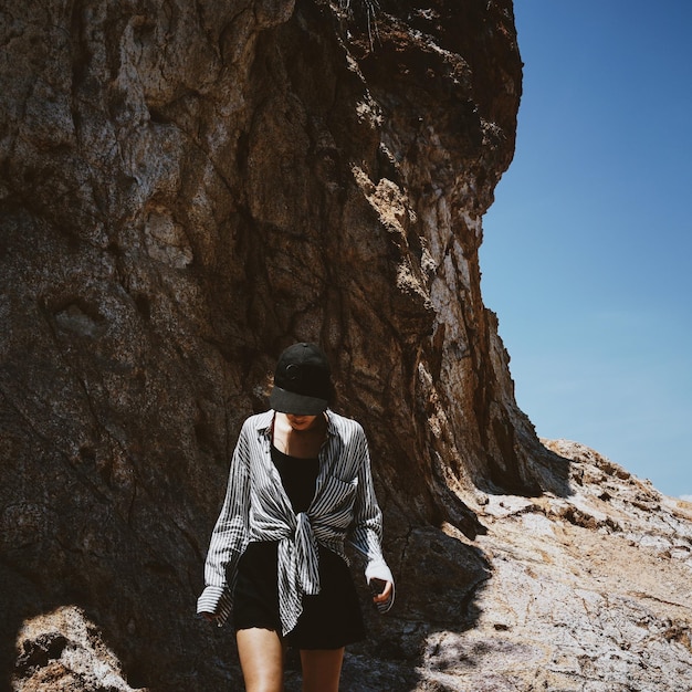 Rear view of hiker standing on rock formation