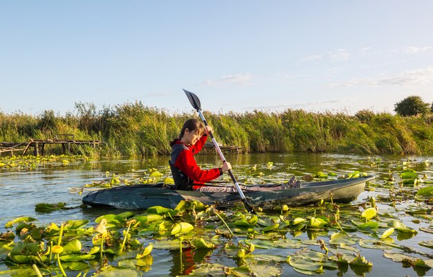 Rear view of kayaker  paddle kayak in summer river