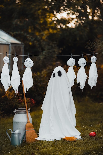 ハロウィーン中に幽霊の衣装を着た子供の後ろの景色