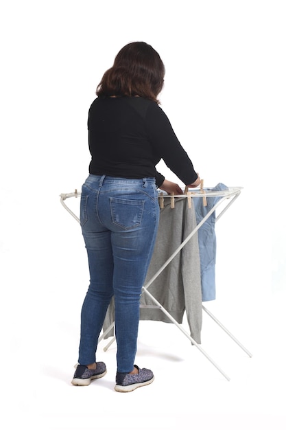 Rear view of a latin woman hanging clothes on white background