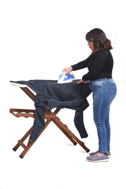 Rear view of a latin woman ironing on white