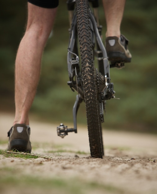 Rear view low angle man legs on mountain bike