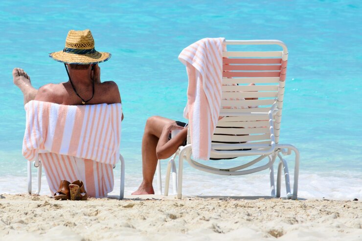 Photo rear view of male friends sitting on chairs at beach