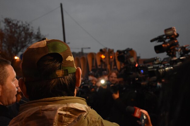 Foto vista posteriore di un uomo contro la città illuminata contro il cielo alle proteste anti-governative a yerevan, in armenia