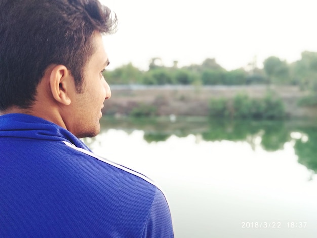 Photo rear view of man against lake